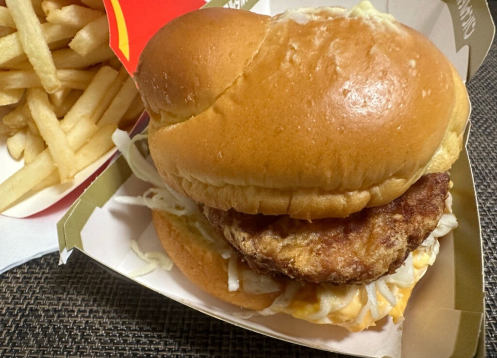 マクドナルドのタルタルチキン南蛮タツタをアップで撮影した写真。ジューシーなチキンパティとシャキシャキのキャベツ、ふわふわのバンズの断面がよく見える構図。