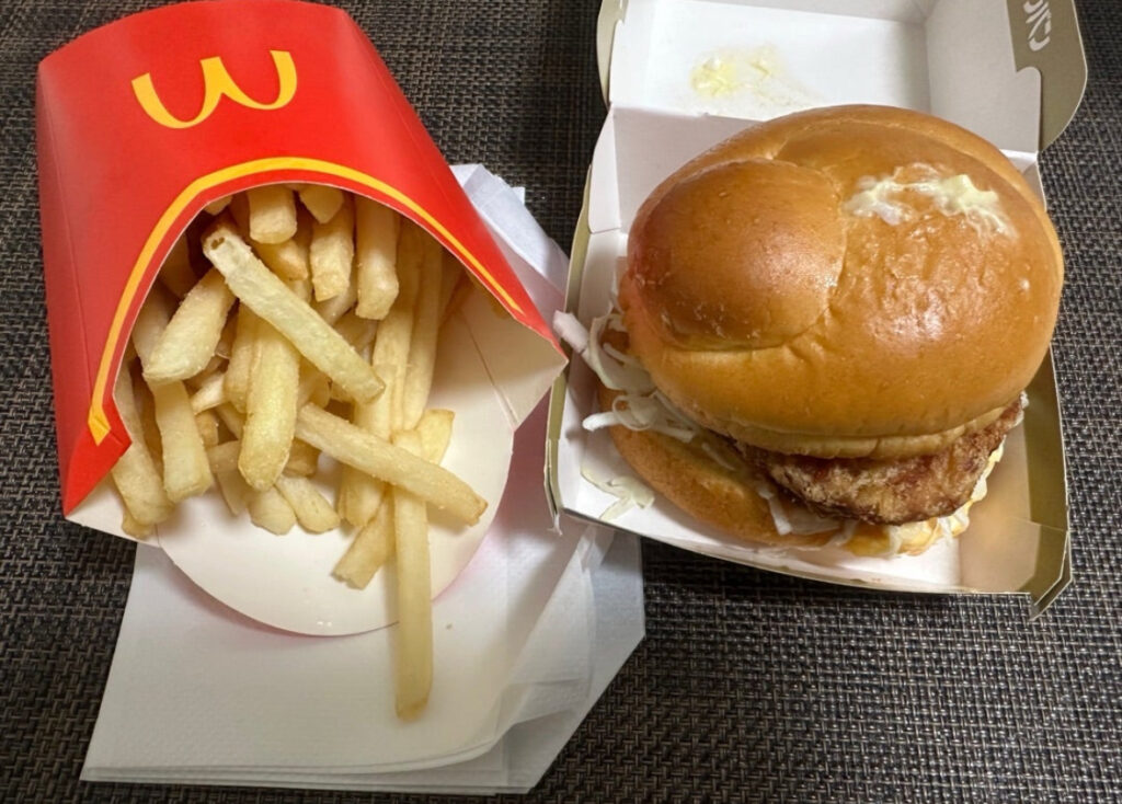 マクドナルドの株主優待を使って注文したタルタル南蛮チキンタツタバーガーとマックフライポテトLサイズのセット。サクサクのポテトとふんわりバンズのチキンタツタがテーブルに並んでいる様子。