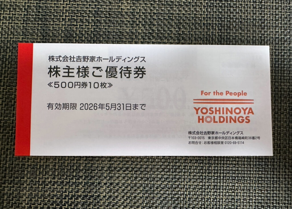 吉野家ホールディングスの株主優待券が入った封筒の中身。右下には、企業情報が印刷されている。