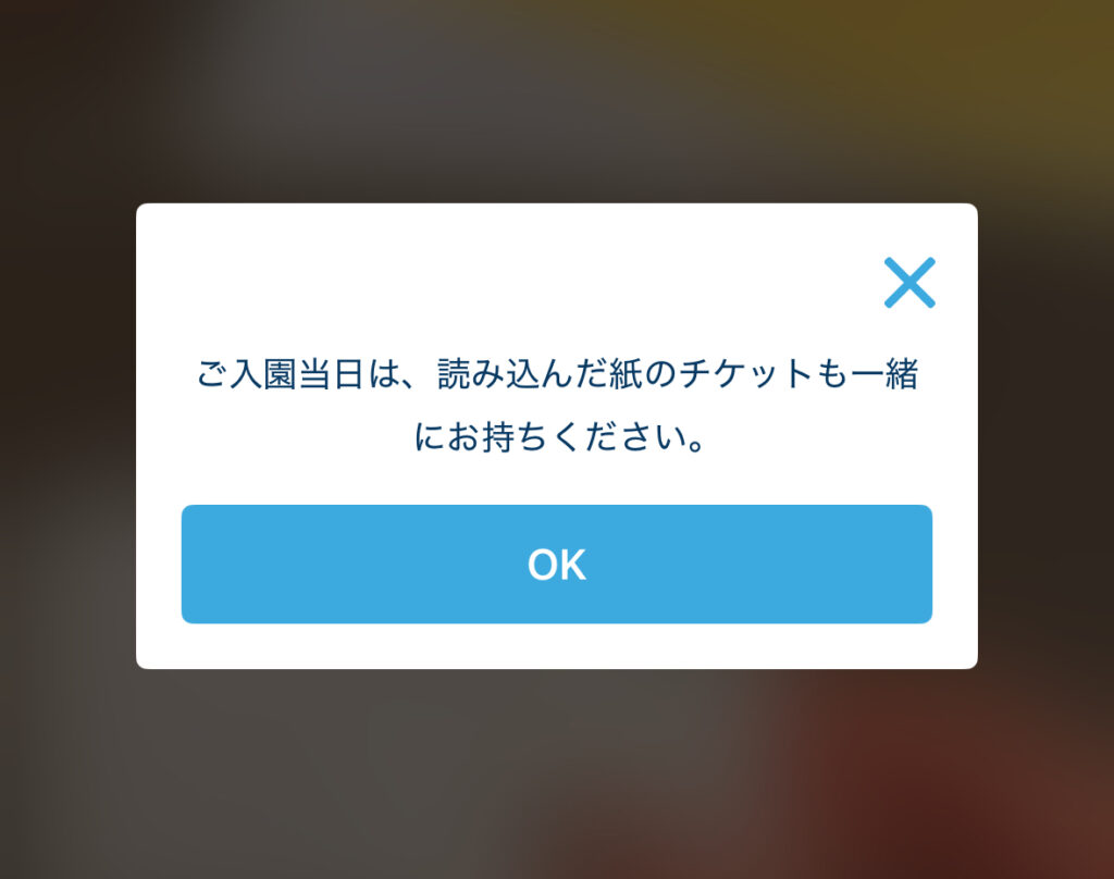 ご入園当日は、読み込んだ紙のチケットも一緒にお持ちください。」という注意メッセージが表示されたアプリ画面。紙チケット携帯の案内。