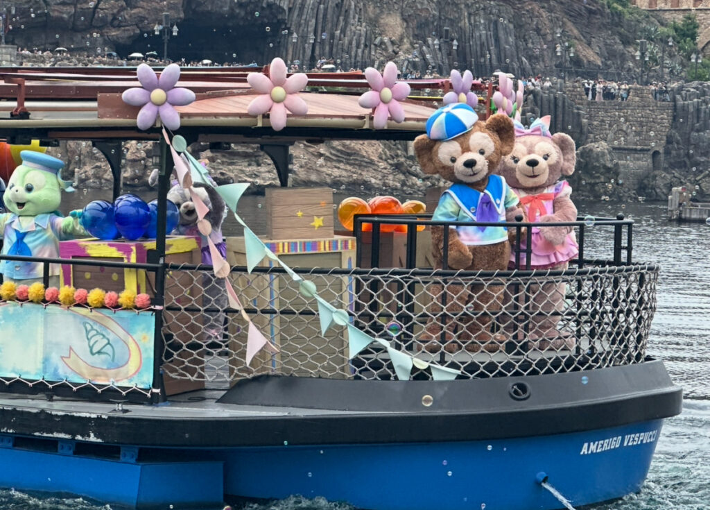 ディズニーシーのハーバーに登場したダッフィー&フレンズの船。色とりどりの装飾が施され、キャラクターたちが手を振って登場する様子。