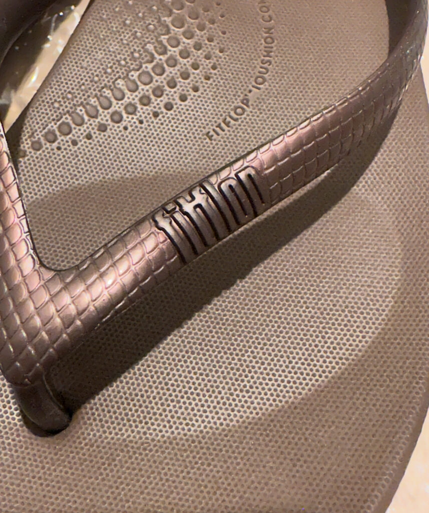 ドウシシャで購入したフィットフロップのサンダルのアップ写真。鼻緒部分にはブランドロゴ「fitflop」が刻まれ、細かい凹凸のあるグリップ付きのインソールが確認できる。