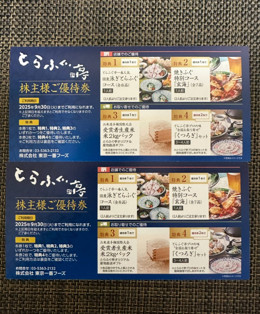 東京一番フーズの株主優待券2枚。とらふぐ亭の「国産泳ぎとらふぐコース」や「焼きふぐ特別コース玄海」など店舗利用特典、または愛媛県産生米2kgや「くつろぎセット」などの通販特典と交換できる内容が記載されている。