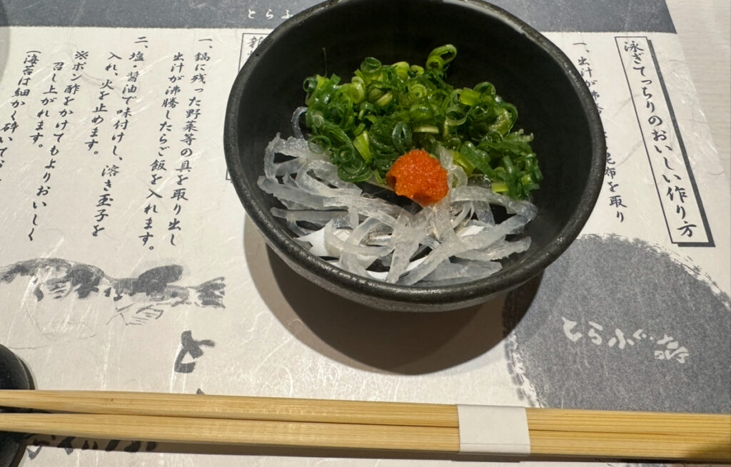 とらふぐ亭で提供された「泳ぎとらふぐの皮刺し」。たっぷりの青ねぎともみじおろしが添えられ、上品な盛り付け。