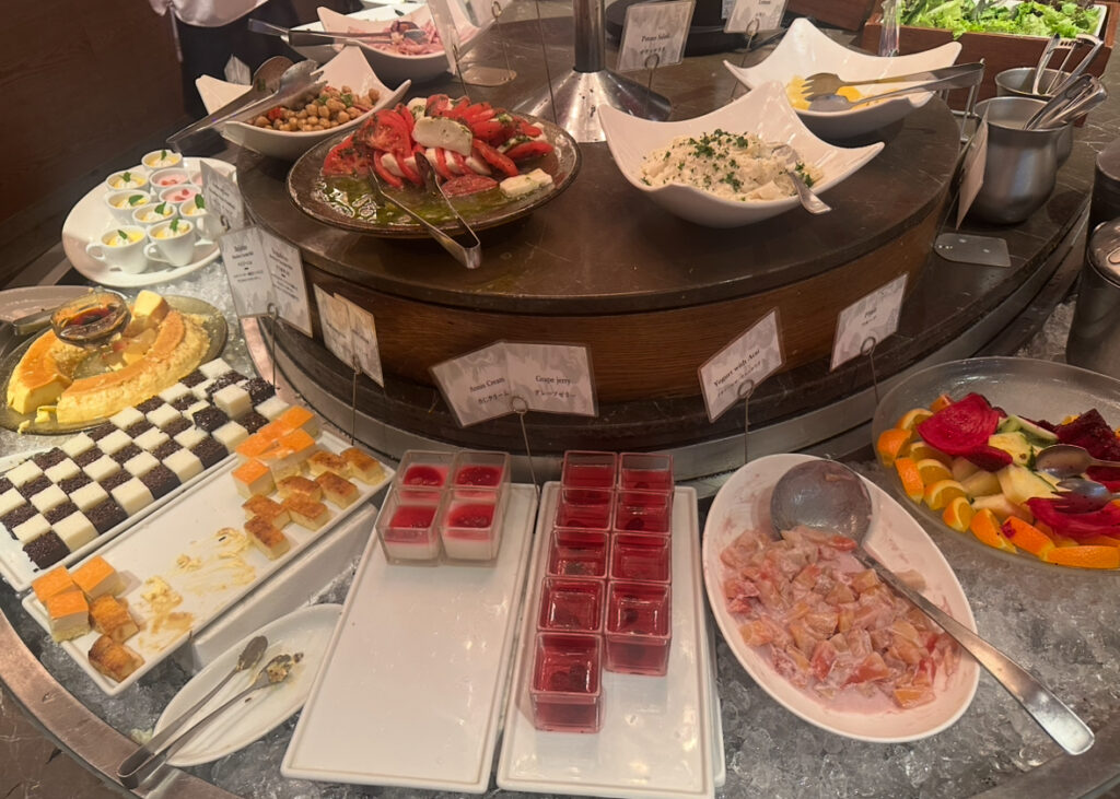 RIO GRANDE GRILL横浜ベイクォーター店のデザートコーナー。プリン、ムース、ゼリー、フルーツ盛り合わせ、パウンドケーキなど種類豊富なスイーツが並ぶ。