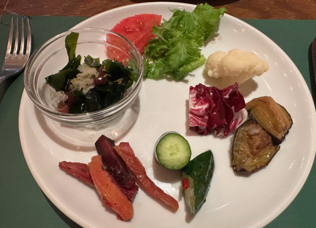 RIO GRANDE GRILL横浜ベイクォーター店で取り分けた前菜プレート。海藻サラダ、トマト、グリーンリーフ、カリフラワー、紫キャベツ、焼きナス、パプリカ、きゅうりなど色とりどりの野菜が並ぶ。