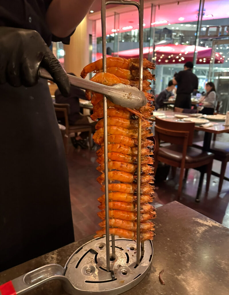 RIO GRANDE GRILL横浜ベイクォーター店のシュラスコ、海老の串焼き。鉄串にぎっしりと並んだ殻付き海老が香ばしく焼かれている。