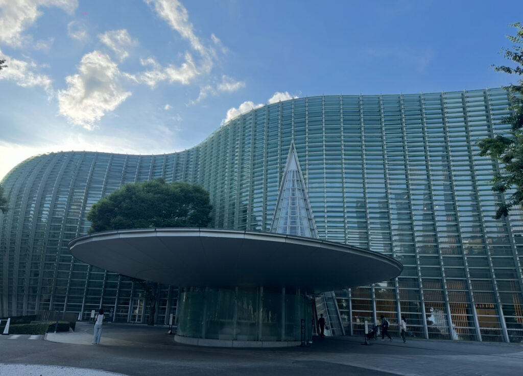 六本木にある国立新美術館の外観。曲線を描く全面ガラス張りの建築が特徴で、「ポール・ボキューズ ミュゼ」はこの建物の3階に位置している。