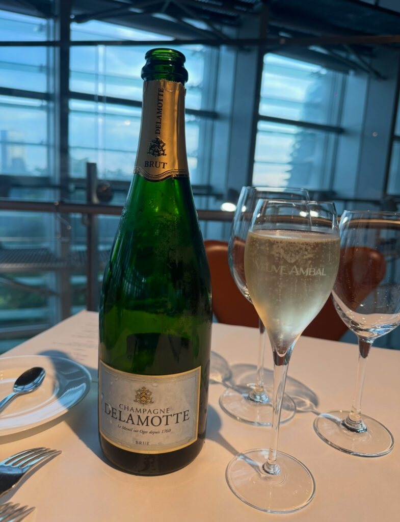 フランスのシャンパーニュ「DELAMOTTE」のボトルと注がれたシャンパングラス。ポール・ボキューズ ミュゼのテーブルにて、ワインペアリング1杯目として提供された。