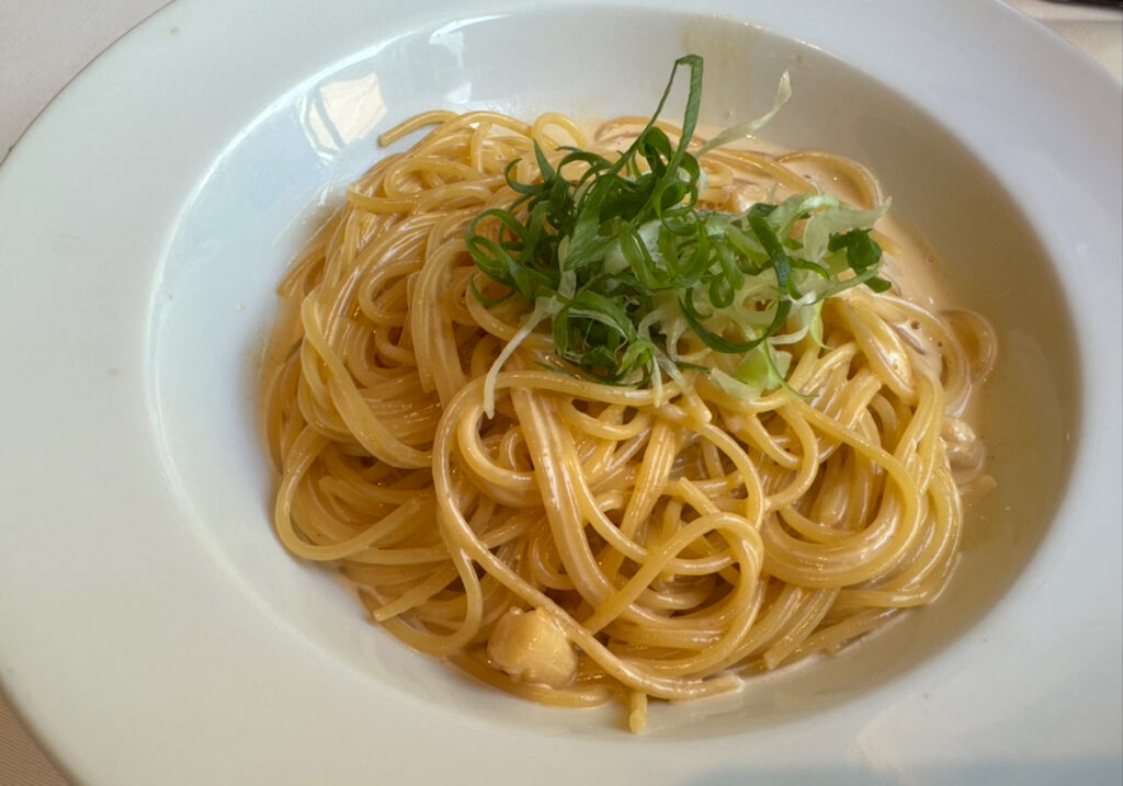 タント タント ザ・ガーデンズ五反田店のランチコースで選べる、雲丹といたや貝柱のクリームパスタ。濃厚なクリームソースに絡むパスタの上に刻みネギが添えられている一皿