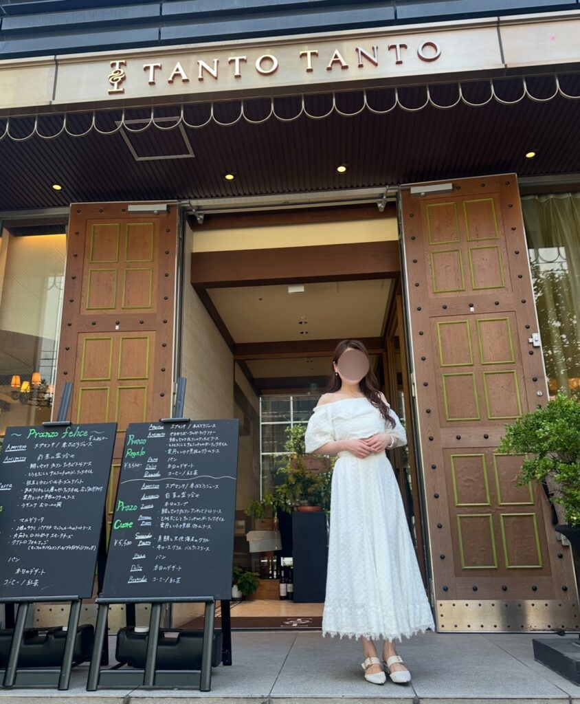 タント タント ザ・ガーデンズ五反田店の入口前で、白いワンピースを着たブログ運営者COCOが立っている写真　※顔はぼかしを入れて掲載しています