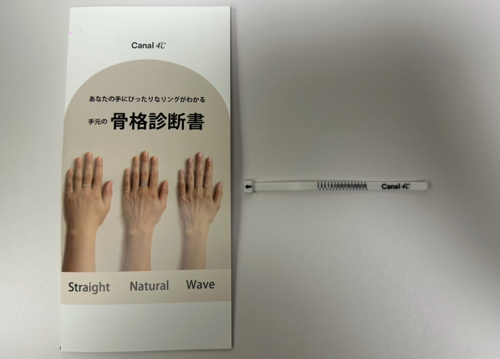 Canal 4℃の手元の骨格診断冊子と、プレゼントとしてもらった白いリングゲージ。手の形に合わせたリングの似合い方を診断してもらえる期間限定のサービス。