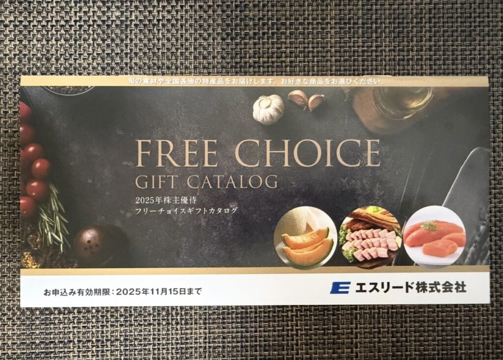 「エスリード株式会社の2025年株主優待『FREE CHOICE GIFT CATALOG』の表紙。黒地にゴールドの文字で高級感のあるデザイン。メロン・お肉・明太子などの写真が並び、下部には申し込み有効期限『2025年11月15日まで』と記載されている。」