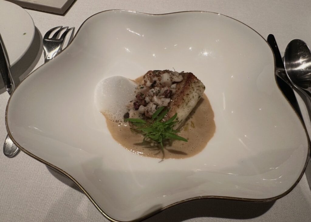サンス・エ・サヴールの魚料理「ハーブバターを纏ったマナガツオと柔らかく煮込んだマダコ」。発酵マッシュルームとシャンパーニュのソースに、レモンの泡が爽やかに香る一皿。