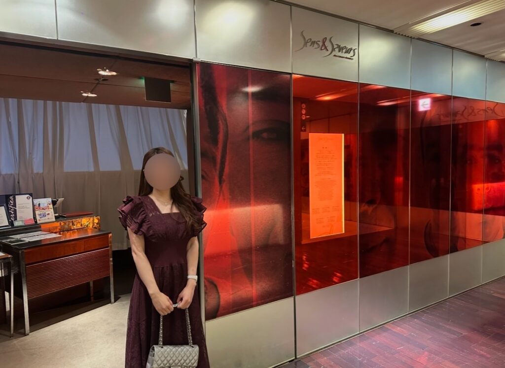 ブログ運営者COCOが、丸の内ビル35階の「サンス・エ・サヴール」入口前で撮影した写真。赤を基調とした洗練された外観が印象的。※顔はぼかしを入れて掲載しています。