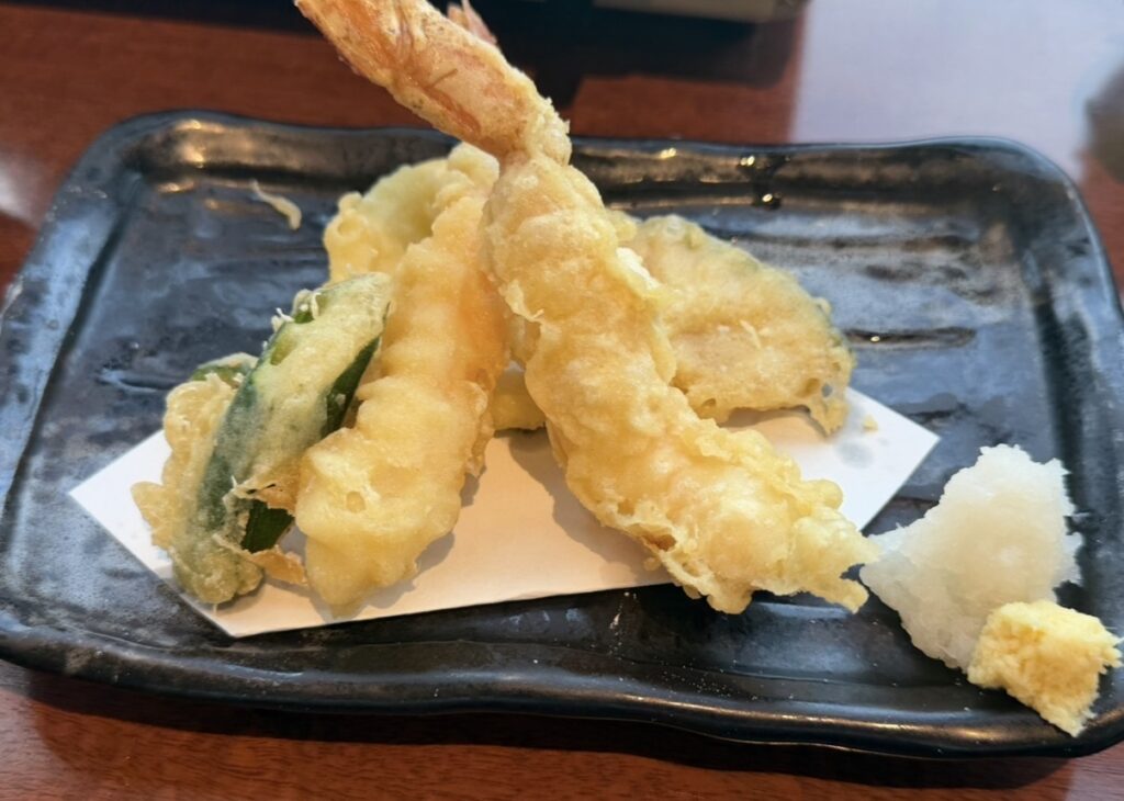 北の味紀行と地酒 北海道の蟹と海老の天麩羅。サクッと揚げられた蟹天と海老天に、野菜天や大根おろしが添えられた一皿。