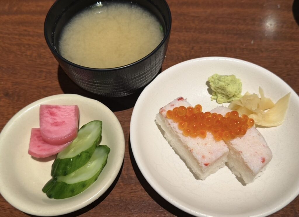 北の味紀行と地酒 北海道のコース料理で提供される蟹押し寿司と味噌汁、お漬物のセット。蟹の押し寿司にはいくらが乗っている日もあり、贅沢感のある人気メニュー。