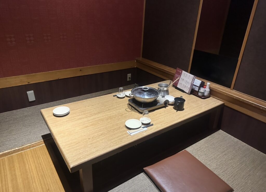 半個室タイプの掘りごたつ席。広めのテーブルで、鍋や料理がゆったり並べられる静かな和の空間。