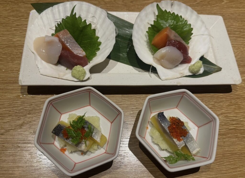 北海道コースの前菜「親子にしん」と、お刺身3種（ホタテ・マグロ・サーモンなど）の盛り合わせ。美しく盛られた貝殻の器が特徴。