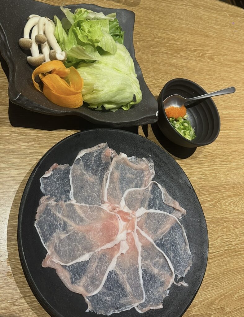 北海道産ゆめの大地豚のしゃぶしゃぶセット。お花のように並べられた薄切り豚肉と、たっぷりの野菜盛り合わせ。