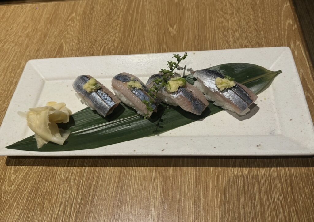 秋の旬ネタ・秋刀魚（さんま）のお寿司5貫が、美しく盛り付けられた和皿の料理写真。