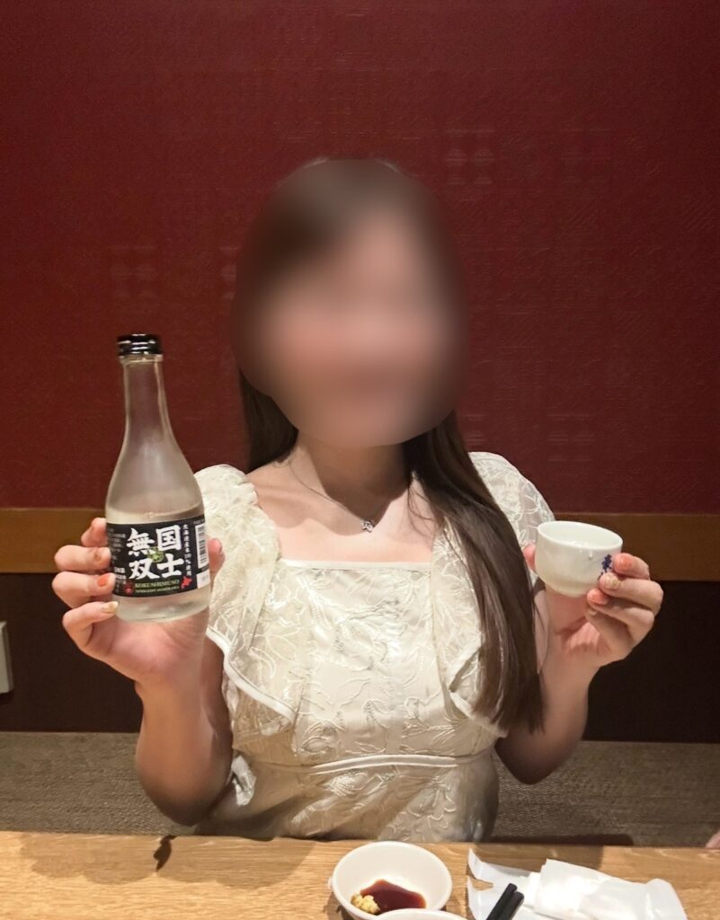 ブログ運営者COCOが日本酒「無国双士」を手に乾杯している様子。※顔はぼかしを入れて掲載しています。