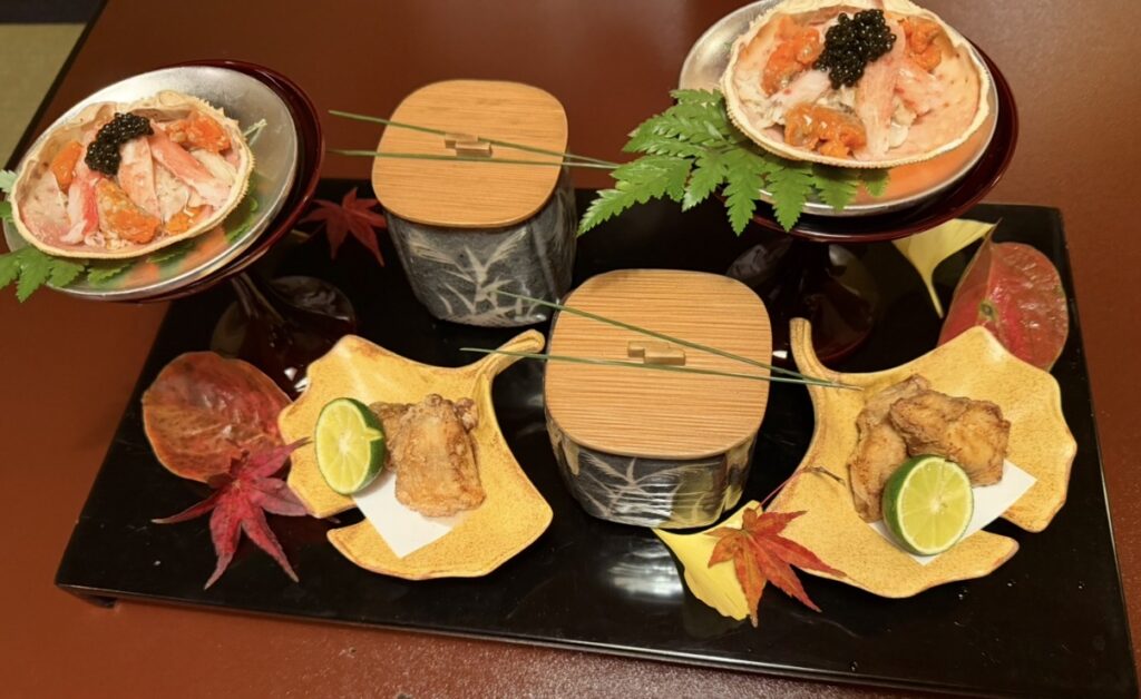 とうふ屋うかい芝店の特別会席で提供された芝の八寸。蟹やいくらを使った小鉢や季節の揚げ物が美しく盛り付けられ、秋の葉が添えられた華やかな前菜の盛り合わせ。