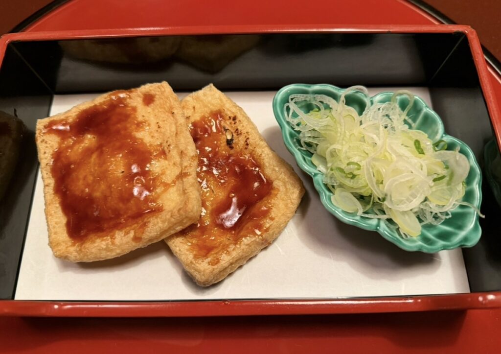 甘味噌がたっぷりかかったうかい名物のあげ田楽と、添えられた刻みねぎ。