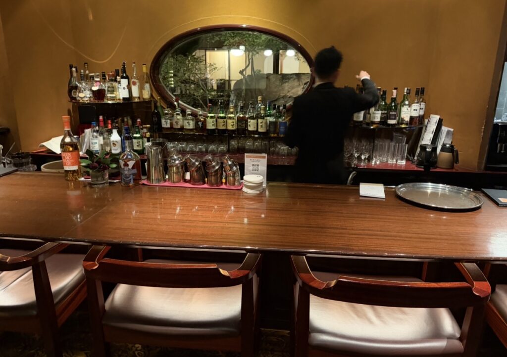 吉祥庵のカウンター席。ウイスキーやリキュールなど多彩なボトルが並ぶバーカウンターで、落ち着いてお酒を楽しめる空間。