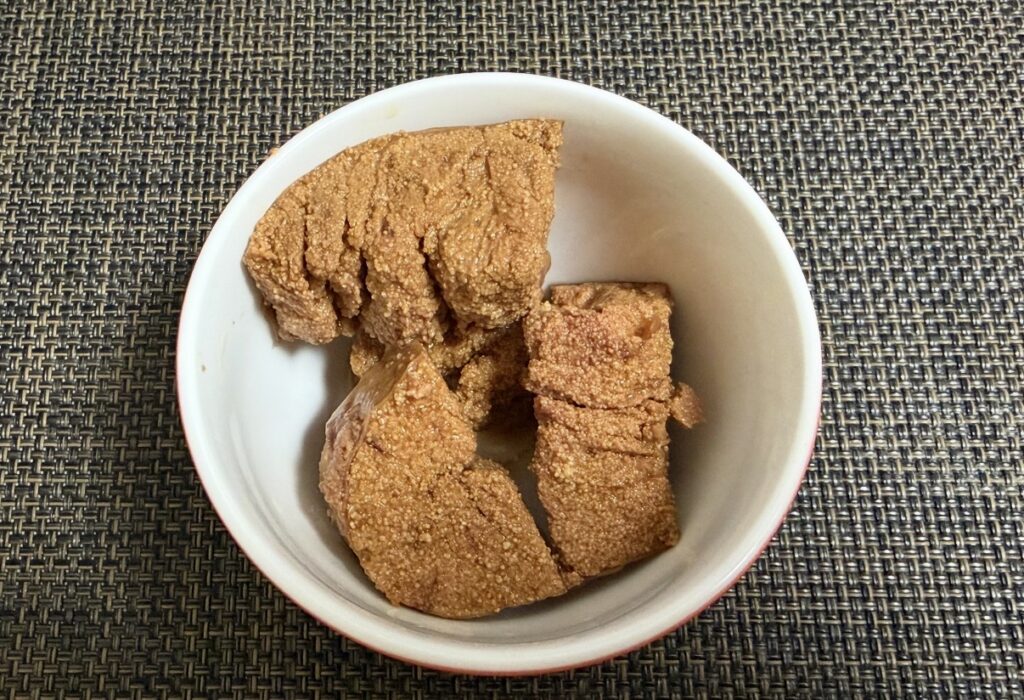 築地魚河岸「希缶」シリーズの『まぐろ卵の甘露煮』の中身を器に移した写真。粒々食感がわかるしっかりとした卵の塊がゴロッと入っており、濃厚な甘辛タレで煮付けられた高級感のあるまぐろの卵料理。
