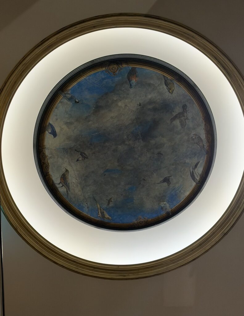 リストランテASOの螺旋階段の天井に描かれた、額賀加津己氏によるフレスコ画「碧空（へきくう）」。青い空と鳥が描かれた幻想的な天井画が、クラシックな洋館の雰囲気をより印象的にしている。