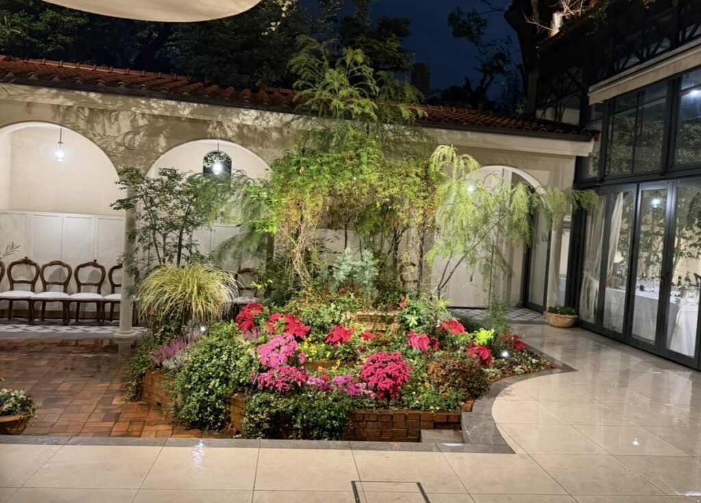 リストランテASOの敷地内にある中庭の様子。樹木や季節の花々に囲まれた庭園が広がり、都心にいながらも落ち着いた雰囲気を感じられる空間。