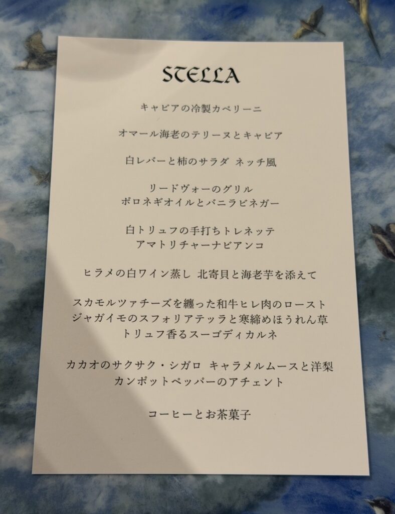 リストランテASOのクリスマス限定特別コース「STELLA」のメニュー表。キャビアの冷製カッペリーニ、オマール海老のテリーヌ、白レバーと柿のサラダ、リードヴォーのグリル、白トリュフの手打ちトレネッテ、ヒラメの白ワイン蒸し、和牛ヒレ肉のロースト、クリスマスデザートとコーヒーまでが並ぶコース内容