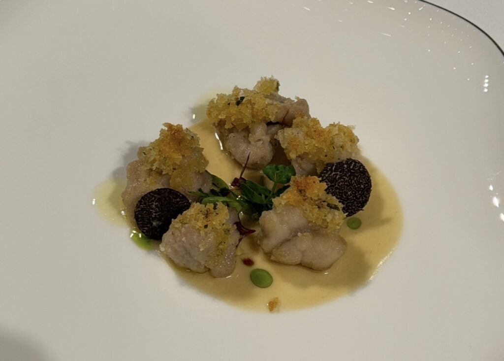 リードヴォーのグリルのアップ写真。サクサクの衣をまとったリードヴォーに、ポロネギオイルとバニラビネガーのソース、トリュフを添えた上品な一皿。
