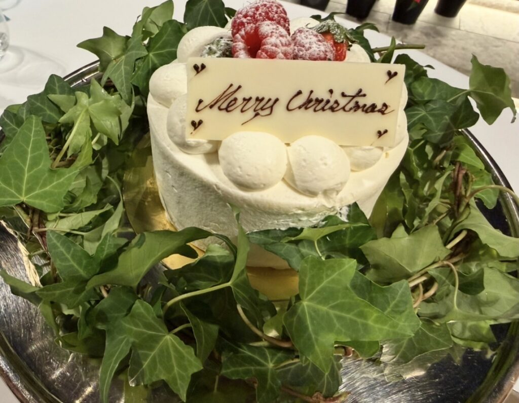 クリスマスディナーで別注文したホールケーキ。アイビーのリースに囲まれ、「Merry Christmas」のチョコレートプレートと苺が飾られた華やかなケーキ