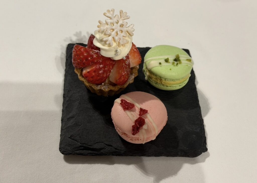 コーヒーと一緒に提供されたお茶菓子のデザートプレート。いちごのタルトとピスタチオ・いちごのマカロンが並び、マカロンはテイクアウト可能