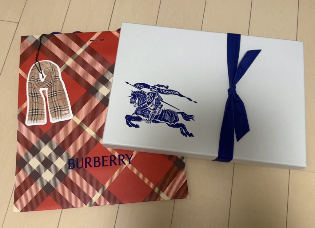 バーバリーで購入したチェック柄カシミアスカーフのギフトラッピング。限定デザインの紙袋と、購入したアイテムが入ったリボン付きのギフトボックス。