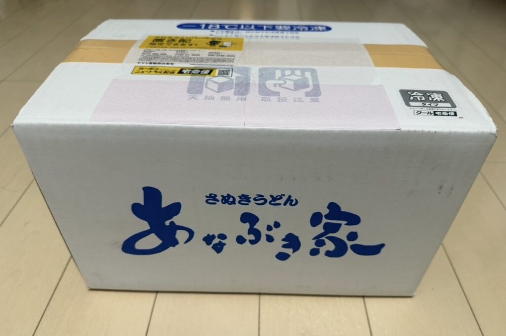 穴吹興産の株主優待で届いた「あなぶき家 冷凍さぬきうどんセット」のクール便の箱｜配達希望日を2月に指定して受け取った様子
