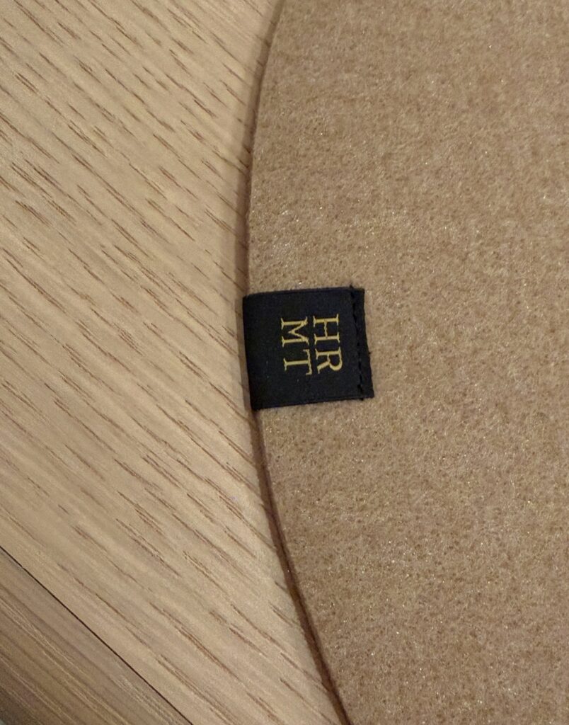 ひらまつ新店舗「HRMT STAGE」のランチョンマットに付けられた店名ロゴのタグ。テーブルウェアの細部までこだわりを感じるディテール。