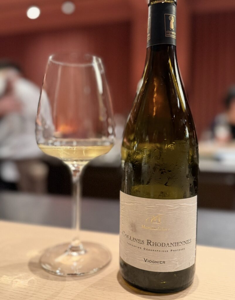 ひらまつ新店舗「HRMT STAGE」のワインペアリング2杯目として提供された白ワイン「コリーヌ・ロダニエンヌ ヴィオニエ」。グラスに注がれた白ワインとボトルの写真。