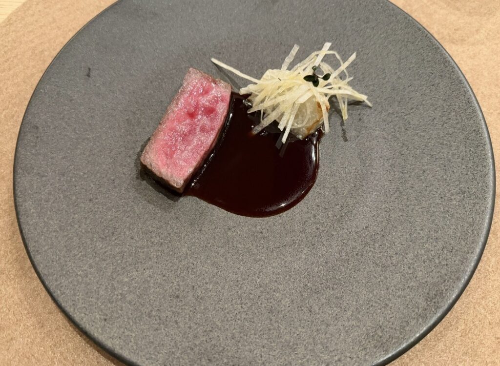 ひらまつ新店舗「HRMT STAGE」のコース料理で提供された、厳選和牛のロースト。蕪のヴァンルージュソースとともに美しく盛り付けられている。