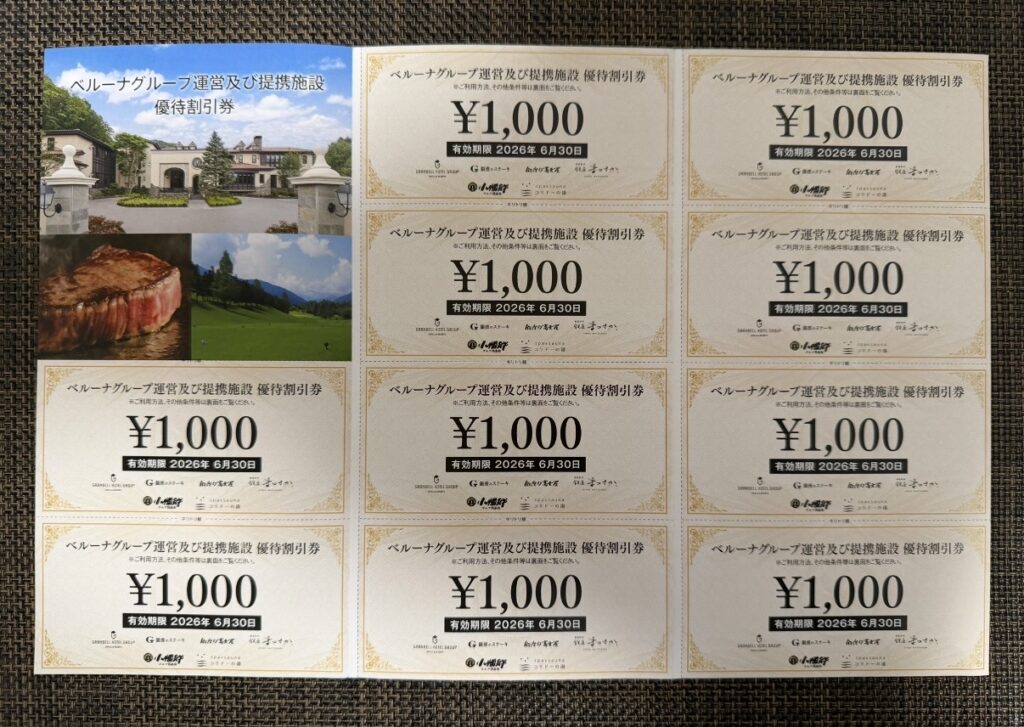ベルーナ（9997）の株主優待として届いたグループ運営・提携ホテル、飲食店、ゴルフ場、スパで使える1,000円分の優待割引券が複数枚並べられている様子。施設イメージ写真が掲載された案内と一緒に撮影されている。