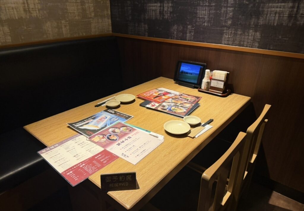 北の味紀行と地酒 北海道の個室席の様子。木目調のテーブルにメニューと取り皿が並び、落ち着いた雰囲気でゆっくり食事ができる空間