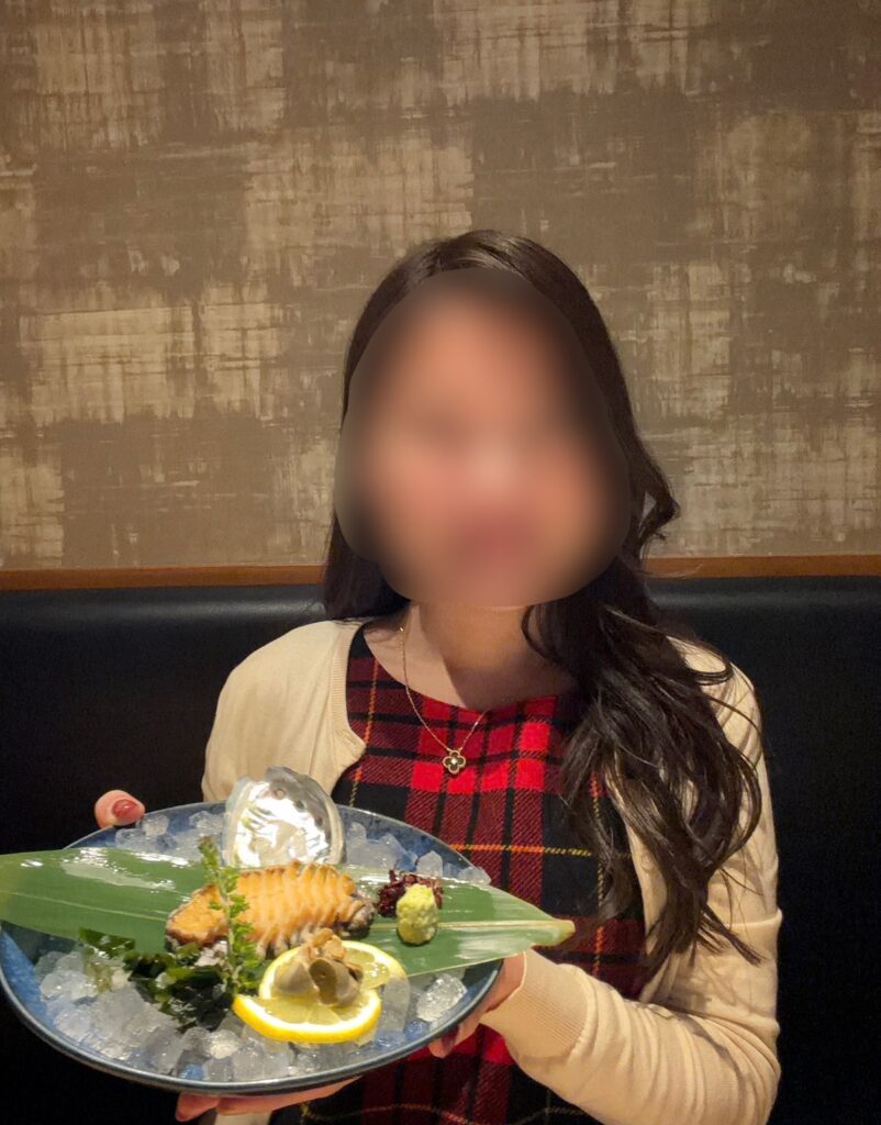 北の味紀行と地酒 北海道で、ブログ運営者が活蝦夷アワビ刺身の盛り合わせを手にしている様子。顔はぼかして掲載