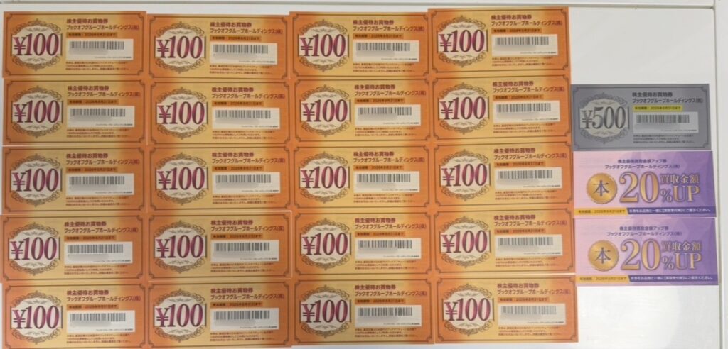 ブックオフの株主優待で届いた2,500円分のお買い物券と、買取金額20％UPクーポンを並べた写真