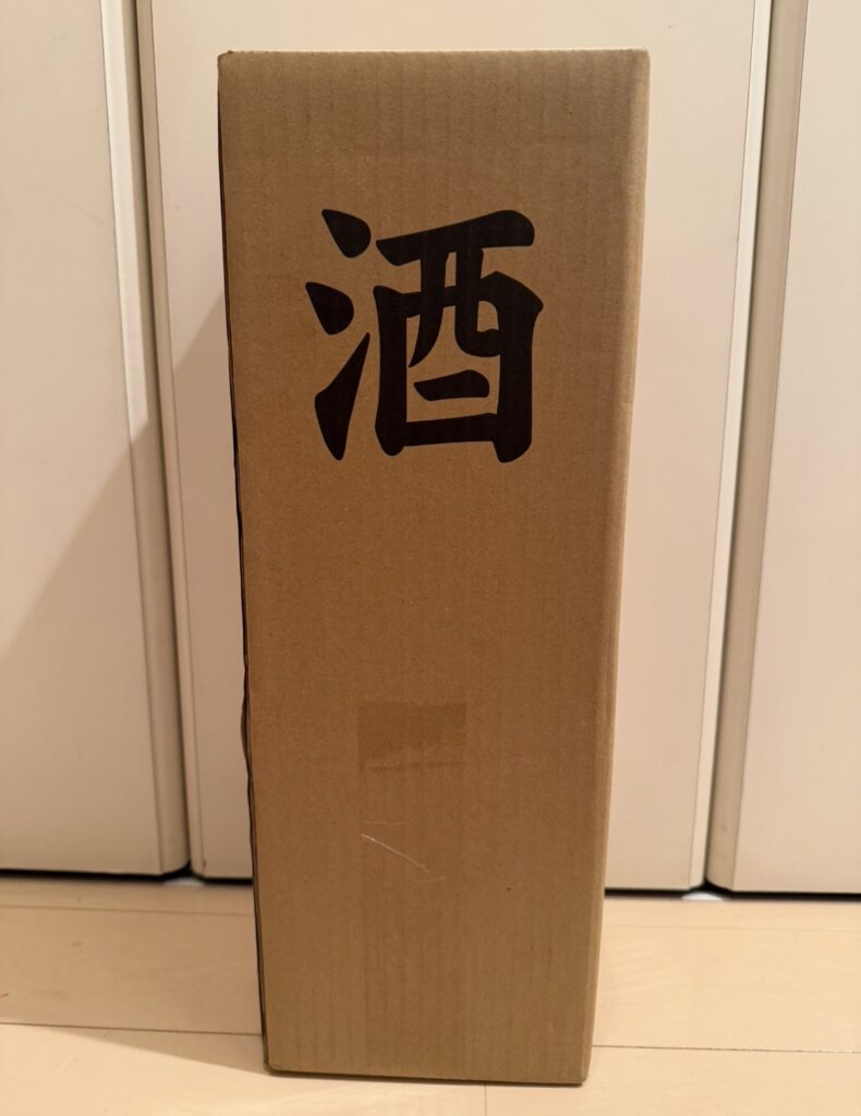 ベルーナ株主優待で届いた日本酒の配送箱。「酒」と書かれた縦長の段ボール箱。