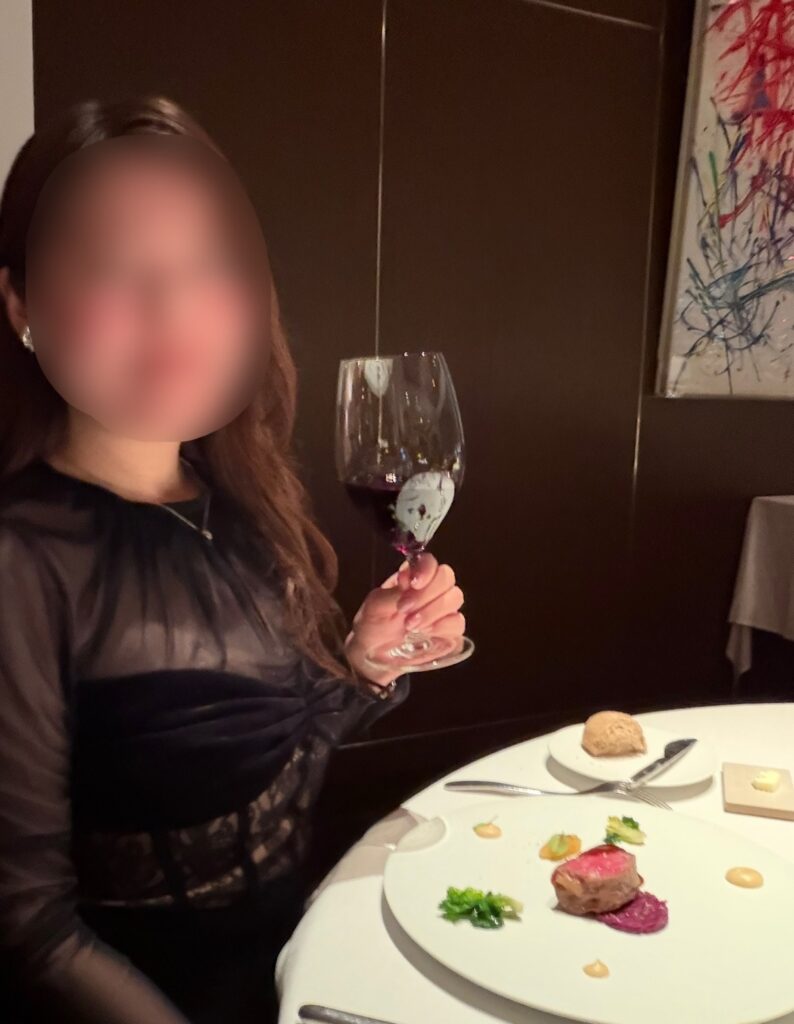 メインの牛サーロイン料理と赤ワインを楽しむブログ運営者COCO(※顔はぼかしを入れて掲載しています)