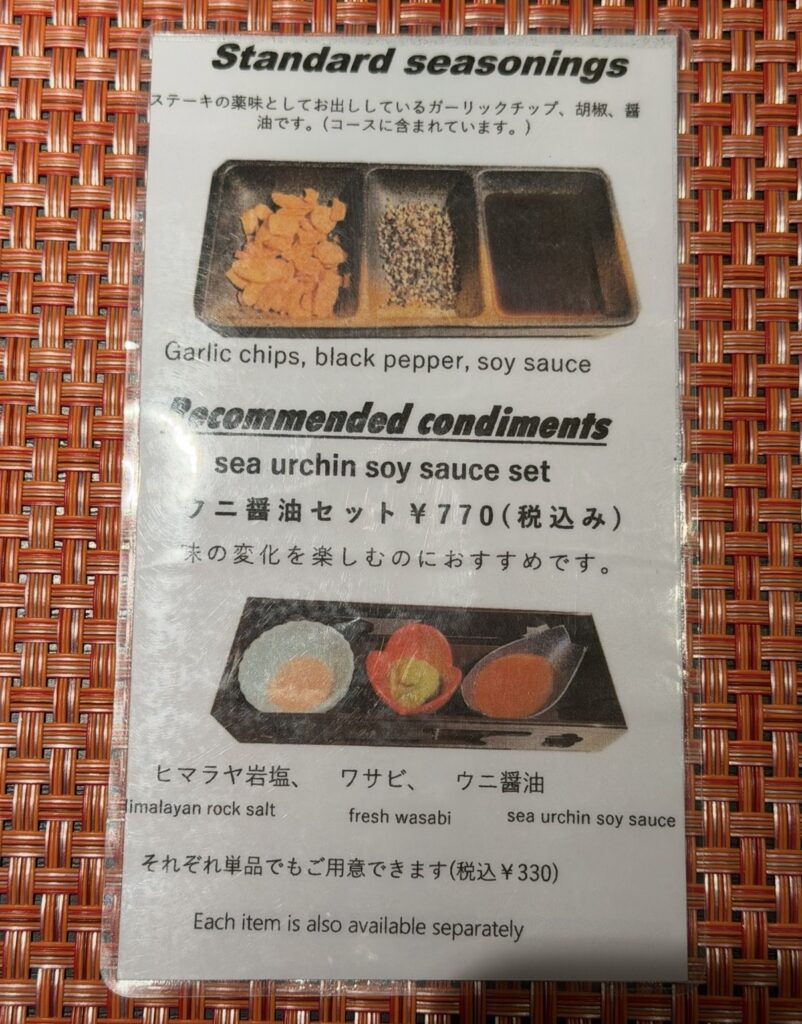 銀座のステーキ銀座本店の調味料案内。ガーリックチップや黒胡椒、醤油に加え、ヒマラヤ岩塩・わさび・ウニ醤油がセットになった追加メニューが紹介されている