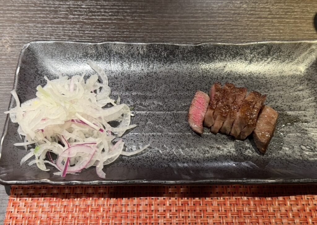 銀座のステーキ銀座本店で焼き上げられたA5黒毛和牛ステーキ。食べやすいサイズにカットされ、サラダが添えられて提供されている