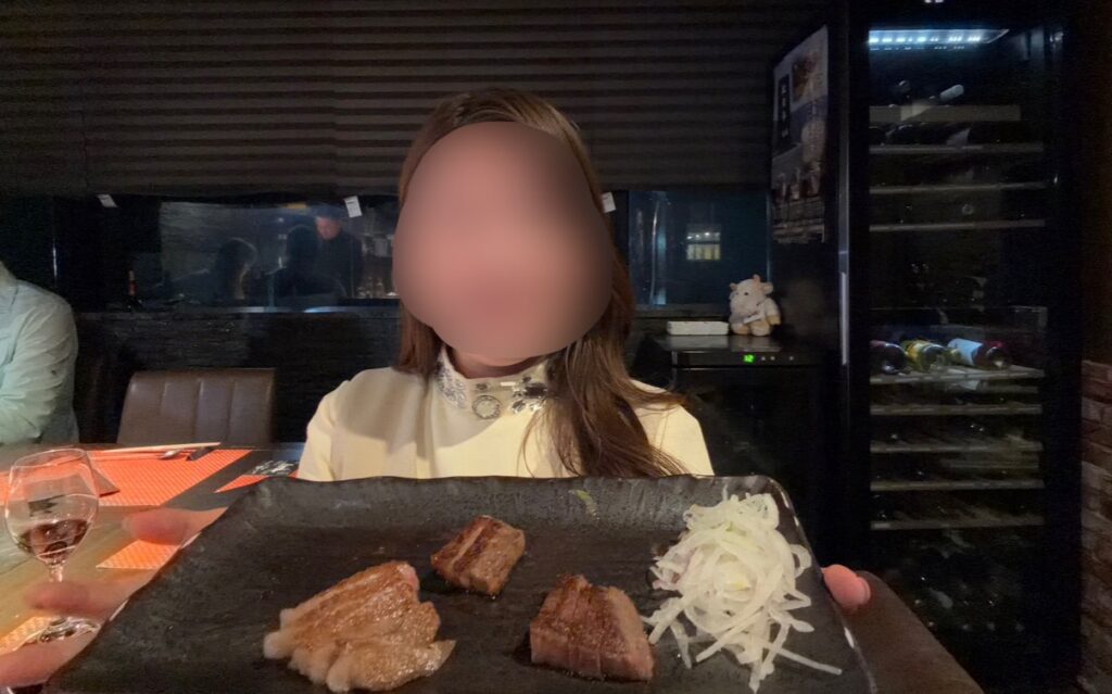 銀座のステーキ銀座本店で追加注文したA5黒毛和牛ステーキを手に持つブログ運営者COCO（※顔はぼかしを入れて掲載しています）